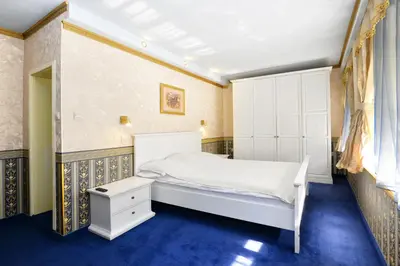 a bedroom with a white bed and blue carpet at Hotel Boyana in Sofia