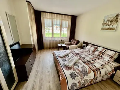 a bedroom with a bed and a desk and a chair at Hani Guest House in Garmen