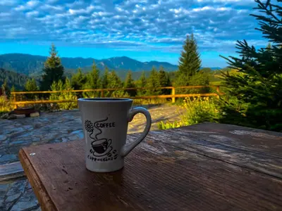 a coffee cup sitting on top of a wooden table at Panorama View-Stoykite in Stoykite