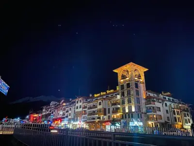 a large building with a clock tower at night at Ski Lift Studio 531 in Bansko