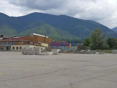 a parking lot with a building and mountains in the background at Ski Lift Studio 531 in Bansko