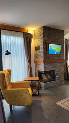 a living room with a fireplace and a tv at HillVill in Govedartsi