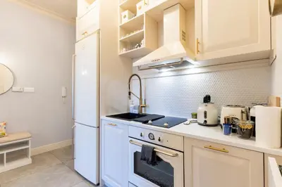 a kitchen with white cabinets and a white refrigerator at Sofia Royal Retreat in Sofia