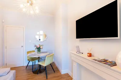 a living room with a table and a tv on a wall at Sofia Royal Retreat in Sofia