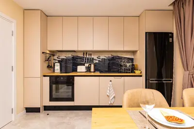 a kitchen with white cabinets and a table at Duos of Delight Matching Urban Apartments for Your Plovdiv Adventure by Flat Mаnager in Plovdiv