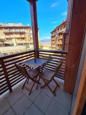 a table and chair on a balcony with a view at Four Seasons Apartment Bansko in Bansko