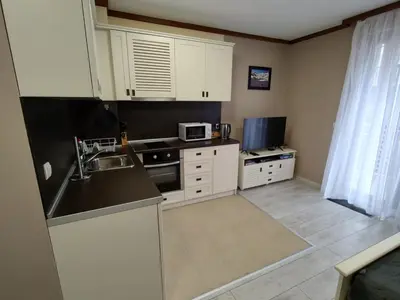 a kitchen with white cabinets and a sink and a microwave at Four Seasons Apartment Bansko in Bansko