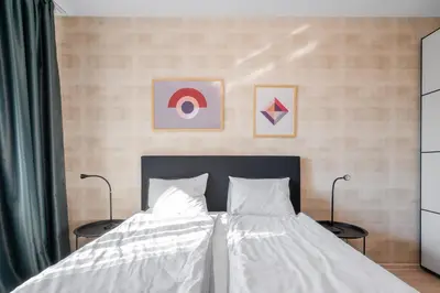 a bedroom with a bed with white sheets and two lamps at Urban Elegance at Its Finest Stylish 1-BD Flat by Flat Mаnager in Sofia