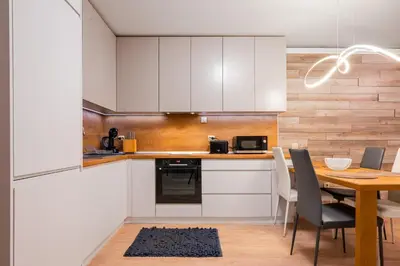 a kitchen with white cabinets and a wooden table at Urban Elegance at Its Finest Stylish 1-BD Flat by Flat Mаnager in Sofia
