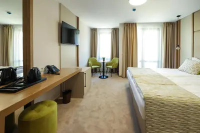 a hotel room with a bed and a table and chairs at Hotel Green Park Service Perfected in Garmen