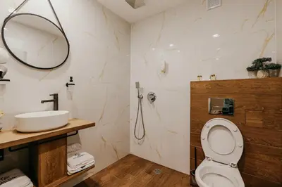 a bathroom with a toilet and a sink at Hotel Green Park Service Perfected in Garmen