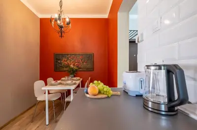 a kitchen with orange walls and a table with a coffee maker at #Maison\u32b6 - A Vibrant, Urban Stay in Sofia