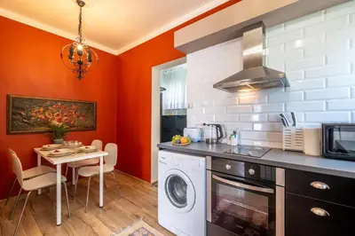 a kitchen with a washing machine and a table at #Maison\u32b6 - A Vibrant, Urban Stay in Sofia