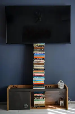 a pile of books sitting on a table under a television at 10 Seconds Away from the Main street, Free Secured Parking in Sofia
