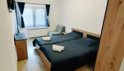 a bedroom with two beds and a chair at Mountain Pearls Home 8 in Vodata