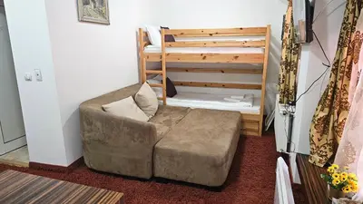 a chair and a ottoman in a room with a bunk bed at The Castle Mansarde on the slope 7 - Pamporovo in Pamporovo