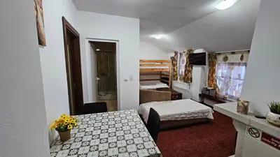 a small room with a table and a bed and a bedroom at The Castle Mansarde on the slope 7 - Pamporovo in Pamporovo