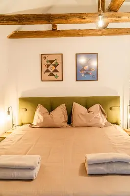 a bedroom with a large bed with two pillows at Къща за гости РАДЕЯ in Govedartsi