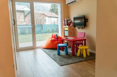 a room with a table and chairs and a television at Къща за гости РАДЕЯ in Govedartsi
