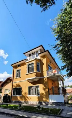 a yellow building on the side of a street at АПАРТАМЕНТ ЮЛИЯ ДЕЛУКС I in Velingrad