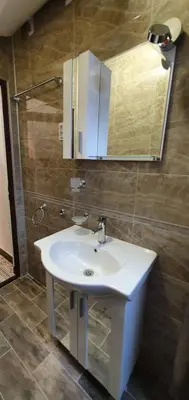 a bathroom with a white sink and a mirror at АПАРТАМЕНТ ЮЛИЯ ДЕЛУКС I in Velingrad