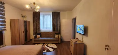 a bedroom with a couch and a chair in a room at АПАРТАМЕНТ ЮЛИЯ ДЕЛУКС I in Velingrad