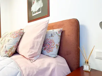 a couch with two pillows on it with a table at 2BR by NDK - AC - Desk - Lux Interior - Balcony in Sofia