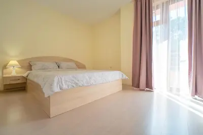 a bedroom with a bed and a large window at Апартамент Амбра in Sandanski