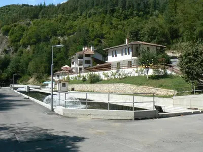 a canal in a road with a house in the background at Fisherman's Hut Family Hotel in Beden