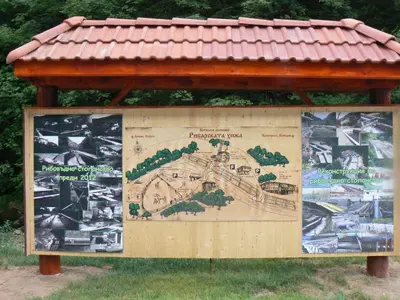 a sign with a map on it in the grass at Fisherman's Hut Family Hotel in Beden