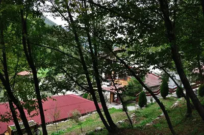 a group of trees in front of a red building at Fisherman's Hut Family Hotel in Beden