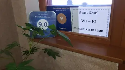 a window sill with a sign on it and a plant at Denis Guest house in Koprivshtitsa