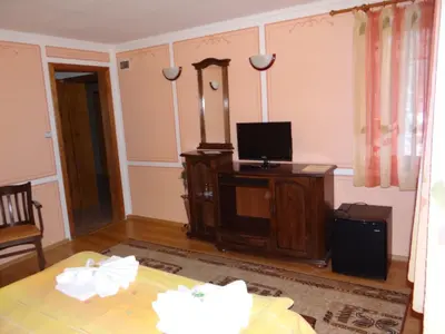a living room with a tv and a table at Denis Guest house in Koprivshtitsa
