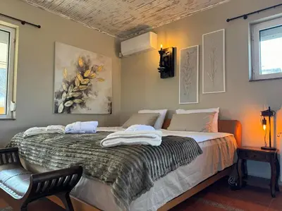 a bedroom with a bed with a chair and a painting at Villa Boyana City & Relax with Hot Jacuzzi and Sauna by BookVillaBG in Sofia