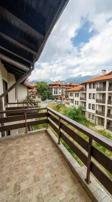 a balcony with a fence and some buildings at Mountain Paradise 2 - Cosy Mountain View Apartment - 200mbps Wifi in Bansko