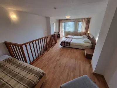 a large room with two beds and a staircase at 1BR Homey Duplex 300mbps WIFI - Two Floor with washer in Bansko