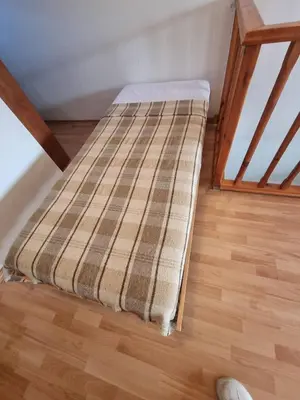 a bed in a room with a wooden floor at 1BR Homey Duplex 300mbps WIFI - Two Floor with washer in Bansko