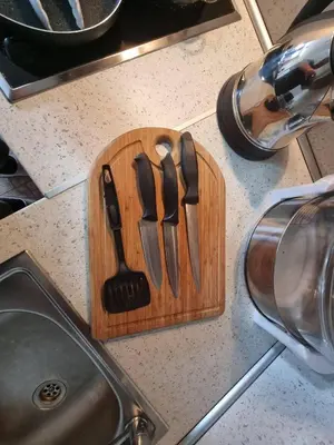 a wooden cutting board with three knives on a counter at 1BR Homey Duplex 300mbps WIFI - Two Floor with washer in Bansko