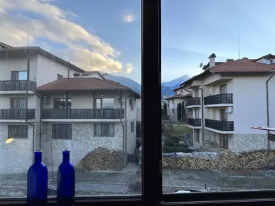 two blue bottles sitting on a window sill with a building at 2BR Mountain View Apartment - Washer, 300mbps WIFI, Aircon in Bansko