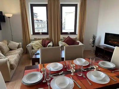 a living room with a table and chairs and a couch at 2BR Mountain View Apartment - Washer, 300mbps WIFI, Aircon in Bansko