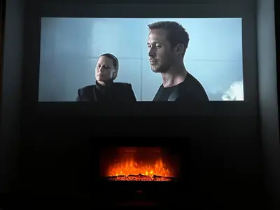 a tv screen with a man standing in front of a fireplace at 2BR Mountain View Apartment - Washer, 300mbps WIFI, Aircon in Bansko