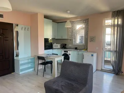 a kitchen with a table and a couch and a table and chairs at APARTHOTEL VICTORY SOFIA in Sofia
