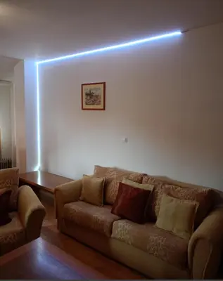 a living room with a couch and a light on the wall at Mountain Paradise 1 - 1 Bedroom South facing balcony - 300mbps Wi-fi in Bansko