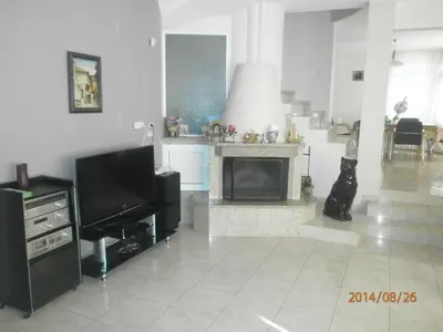 a living room with a television and a fireplace at Славина къща in Perushtitsa