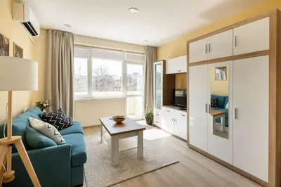 a living room with a blue couch and a table at Central located 1BDR peaceful apt Fast Wi-fi in Sofia