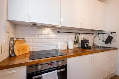 a kitchen with white cabinets and a counter top at Top Centre 1 Bedroom Apt next to Vitosha Blvd. in Sofia