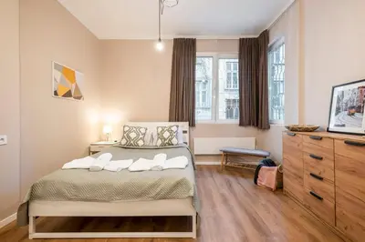 a bedroom with a bed and a dresser at Top Centre 1 Bedroom Apt next to Vitosha Blvd. in Sofia