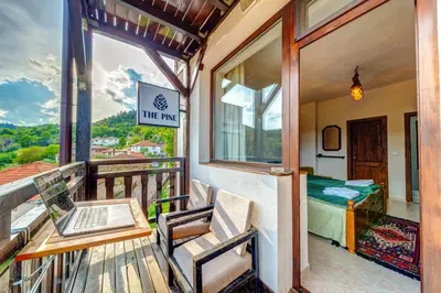 a balcony with a table and a laptop on it at The Pine Living - Ski & SPA in Lyevochevo