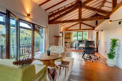a living room with large windows and a table and chairs at The Pine Living - Ski & SPA in Lyevochevo