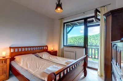 a bedroom with a bed and a large window at The Pine Living - Ski & SPA in Lyevochevo